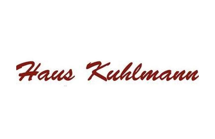 Rotes, geschwungenes Schriftzug-Logo mit den Worten &bdquo;Haus Kuhlmann&ldquo; auf wei&szlig;em Hintergrund.