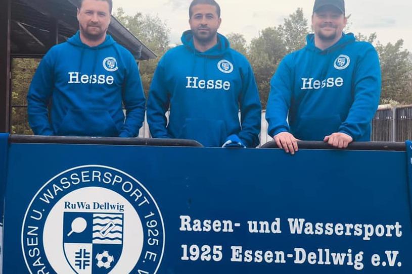 Drei M&auml;nner in blauen Hoodies stehen an einem Tisch mit dem Logo von Rasen- und Wassersport 1925 Essen-Dellwig e.V.