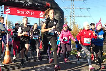 Start eines Kinderlaufs mit mehreren laufenden Teilnehmern unter einem gro&szlig;en Startbogen bei klarem Wetter.